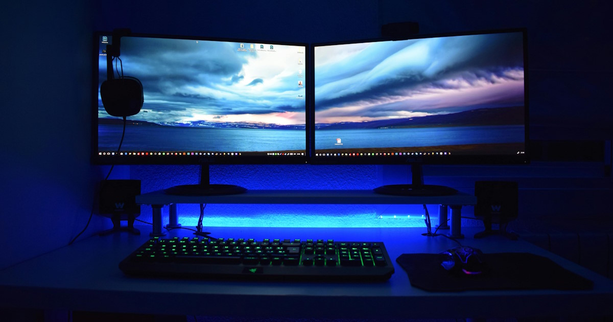 Dual monitor computer setup with blue lighting representing affordable website design for Hawaii businesses