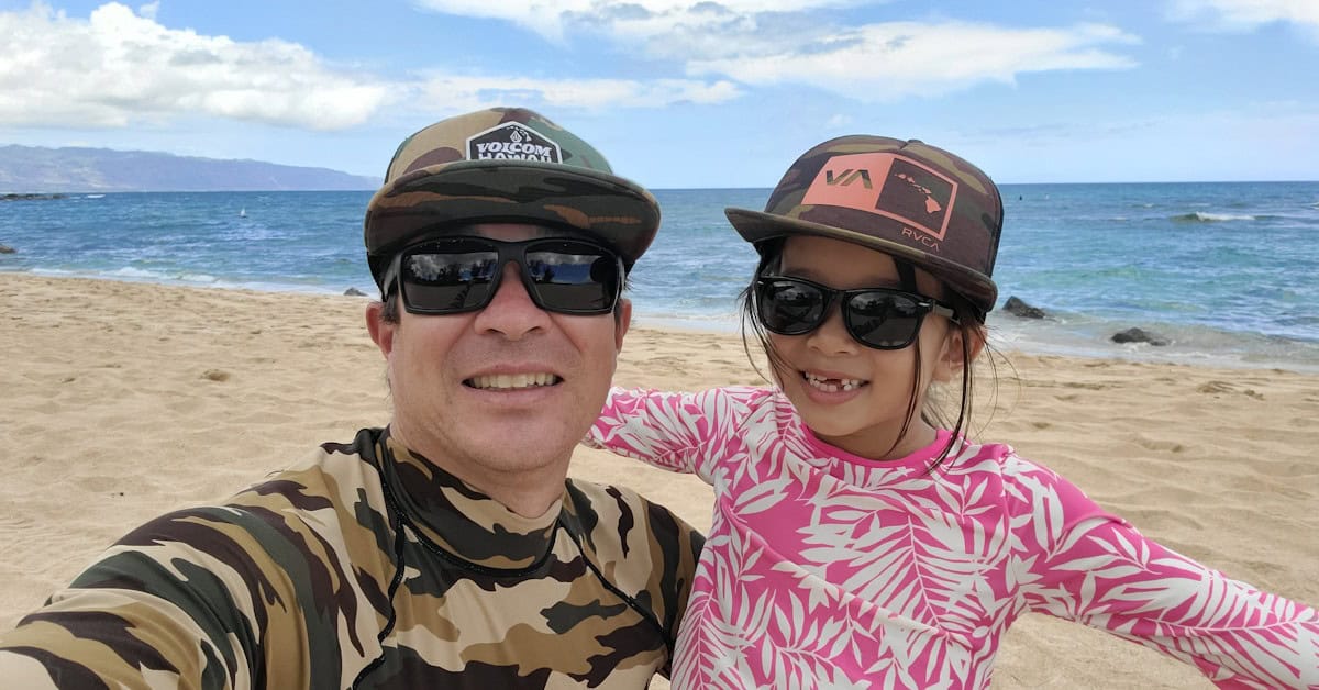 Father and daughter web design team in Hawaii, Clean Design Launch founders Cheyne and Marlie Settlemire smiling at the beach.