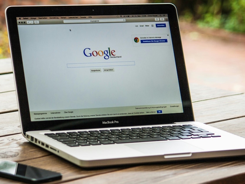 Laptop on a table displaying Google search results representing website versus Google Business Profile comparison