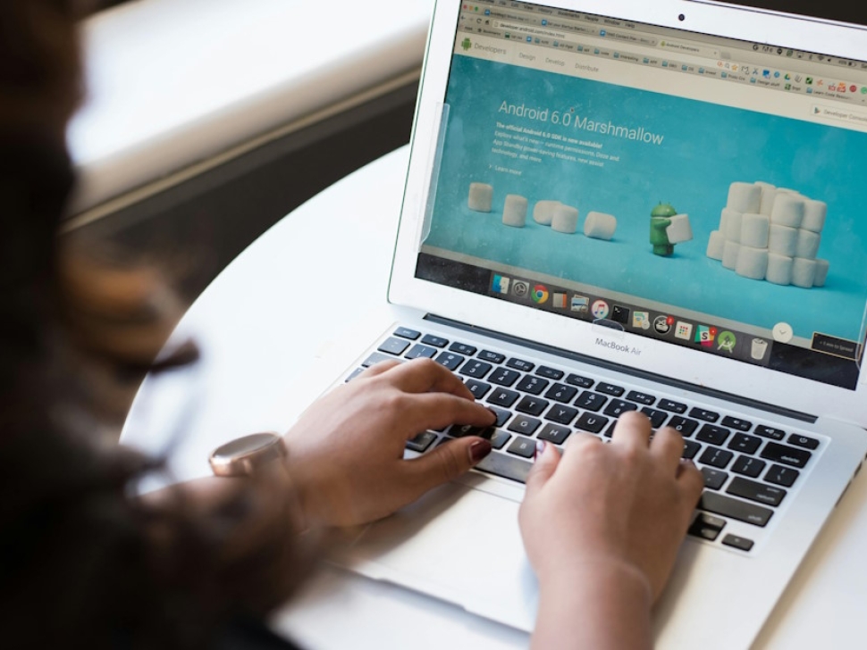 Person working on a laptop reviewing a website homepage layout