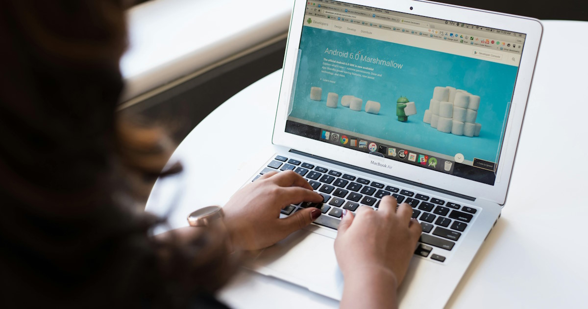 Person working on a laptop reviewing a website homepage layout